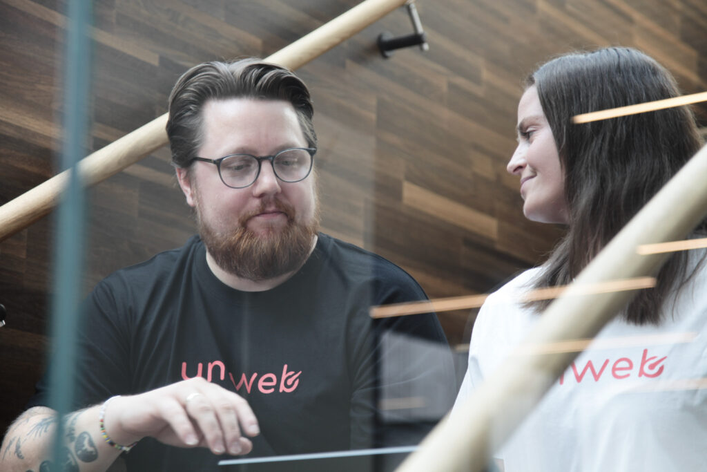 Bilde av to uniweb support ansatte som har en prat