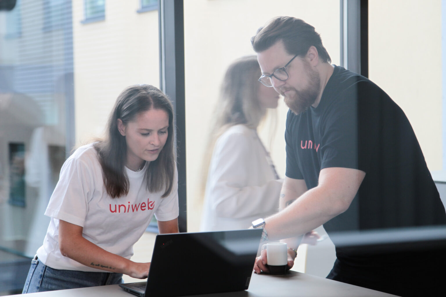 Bilde av to uniweb support ansatte som har en prat