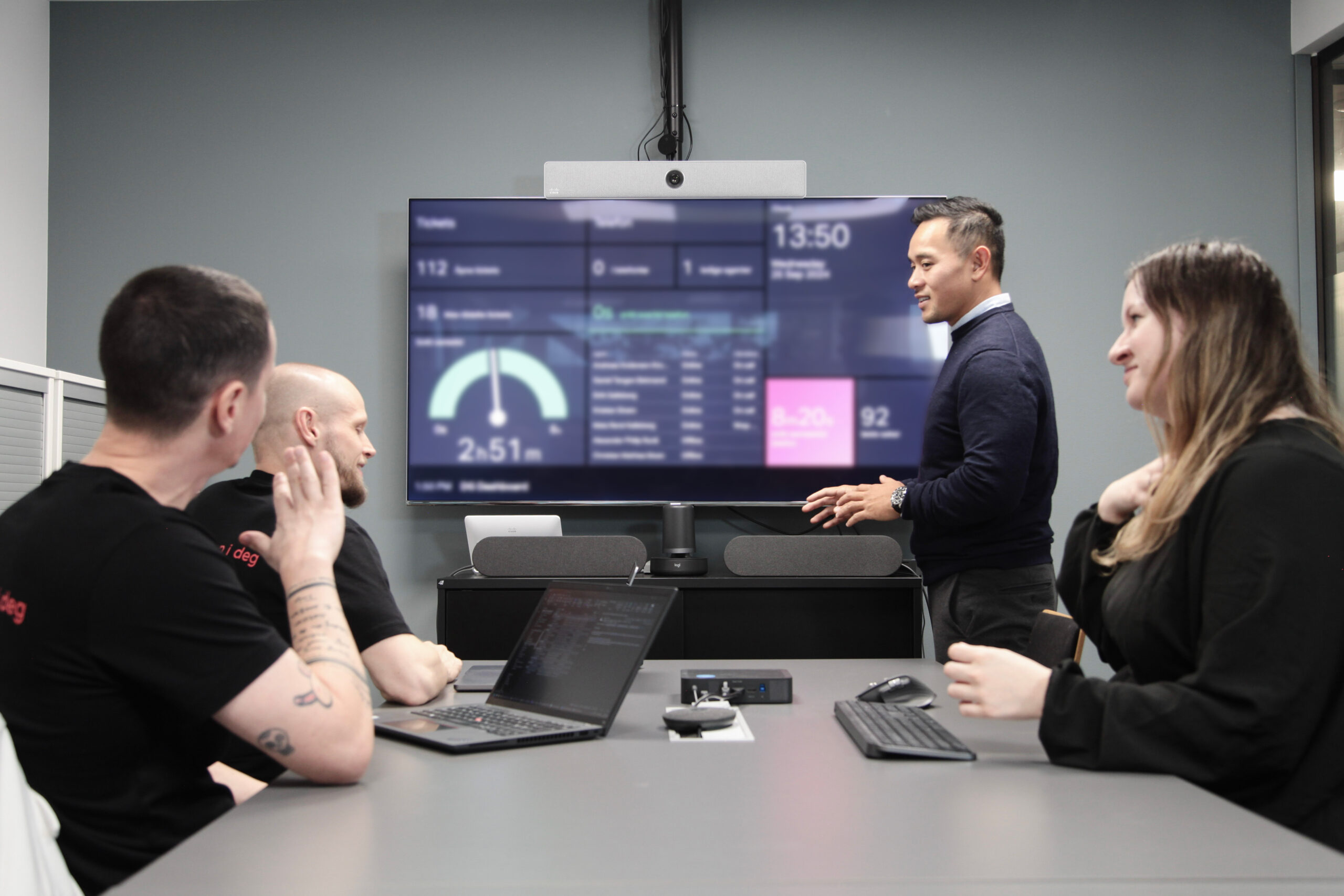 En person som holder et en presentasjon for kolleger i et møterom.